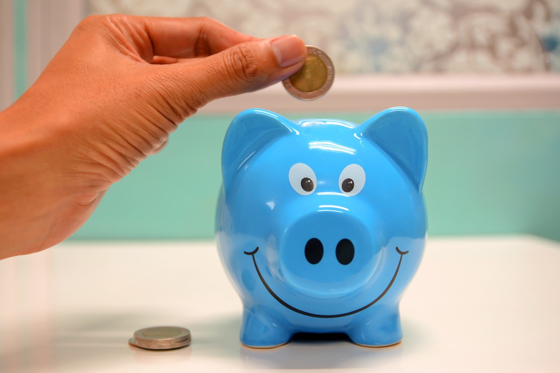 Inserting coin to piggy bank 3 - Reasons Why You Must Start on Investing Smart