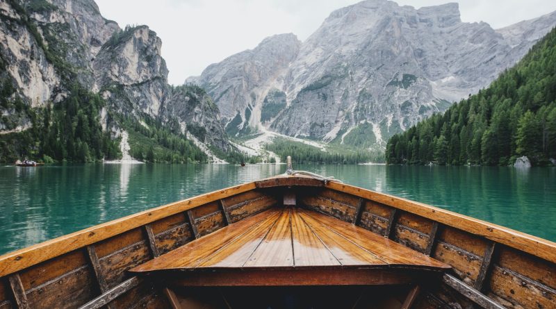 boat floating in a lake between mountains 800x445 - 7 Reasons to Book Your Next Trip With a Travel Agency