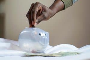 person putting coin in a piggy bank 300x200 - person putting coin in a piggy bank.jpg