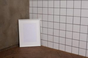 empty white photo frame placed on parquet in room corner against tiled wall 300x200 - empty white photo frame placed on parquet in room corner against tiled wall.jpg