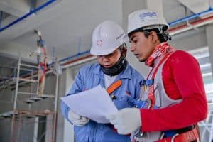 two engineers in safety helmets reviewing construction plans at a worksite 300x200 - two engineers in safety helmets reviewing construction plans at a worksite..jpg