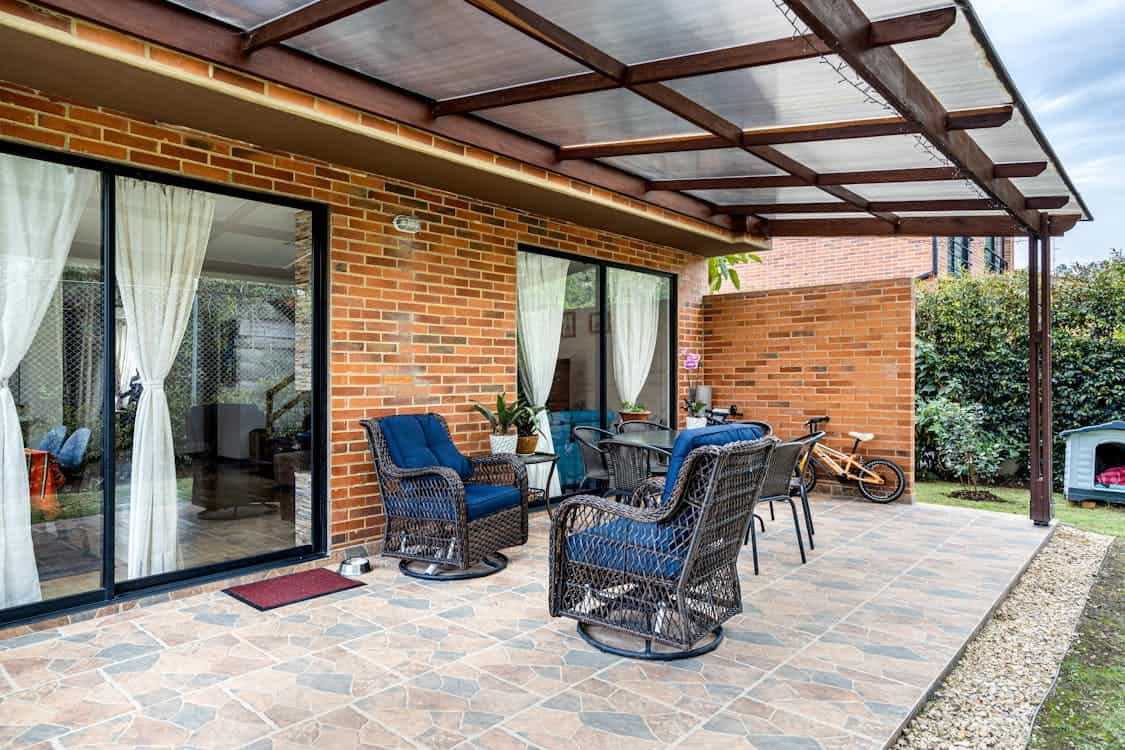 Black Wicker Chairs on a Porch with Translucent Roo - Is Your Patio Too Hot? Here&rsquo;s Why You Need Shade Now