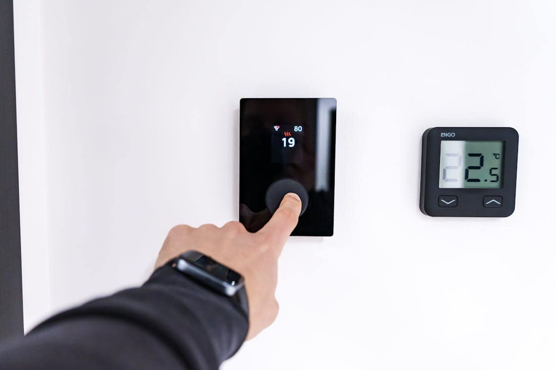 Modern Home Thermostat Adjusted by Hand - 5 Air Conditioner Maintenance Tips for Better Efficiency