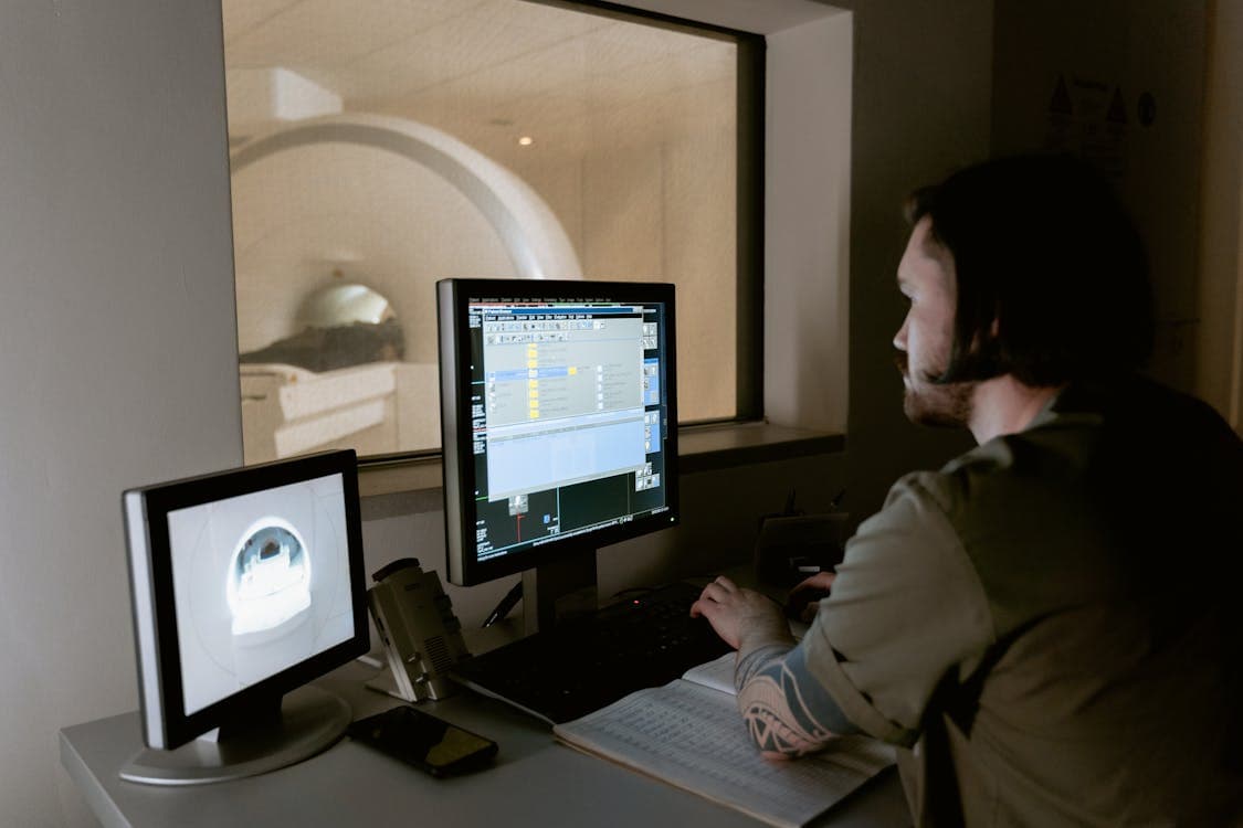 medical worker looking at the monitor - Understanding the Benefits of AI for Imaging Laboratories