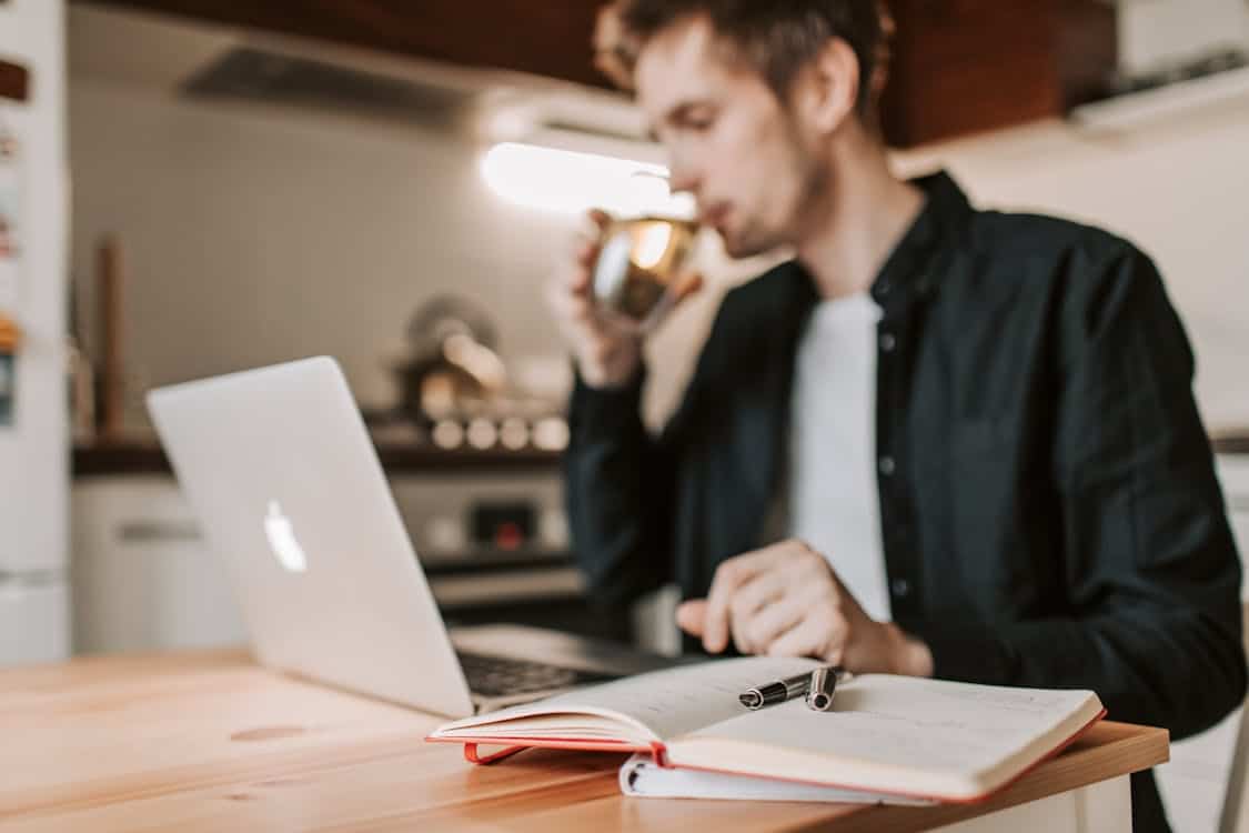 The Time Zone Difference Crushing Remote Workers Is Forcing a Shift to Async Work man works remotely in a kitchen - The Time Zone Difference Crushing Remote Workers Is Forcing a Shift to Async Work