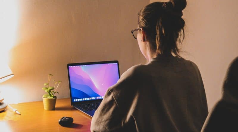 woman focuses on her laptop at a cozy home office The Time Zone Difference Crushing Remote Workers Is Forcing a Shift to Async Work