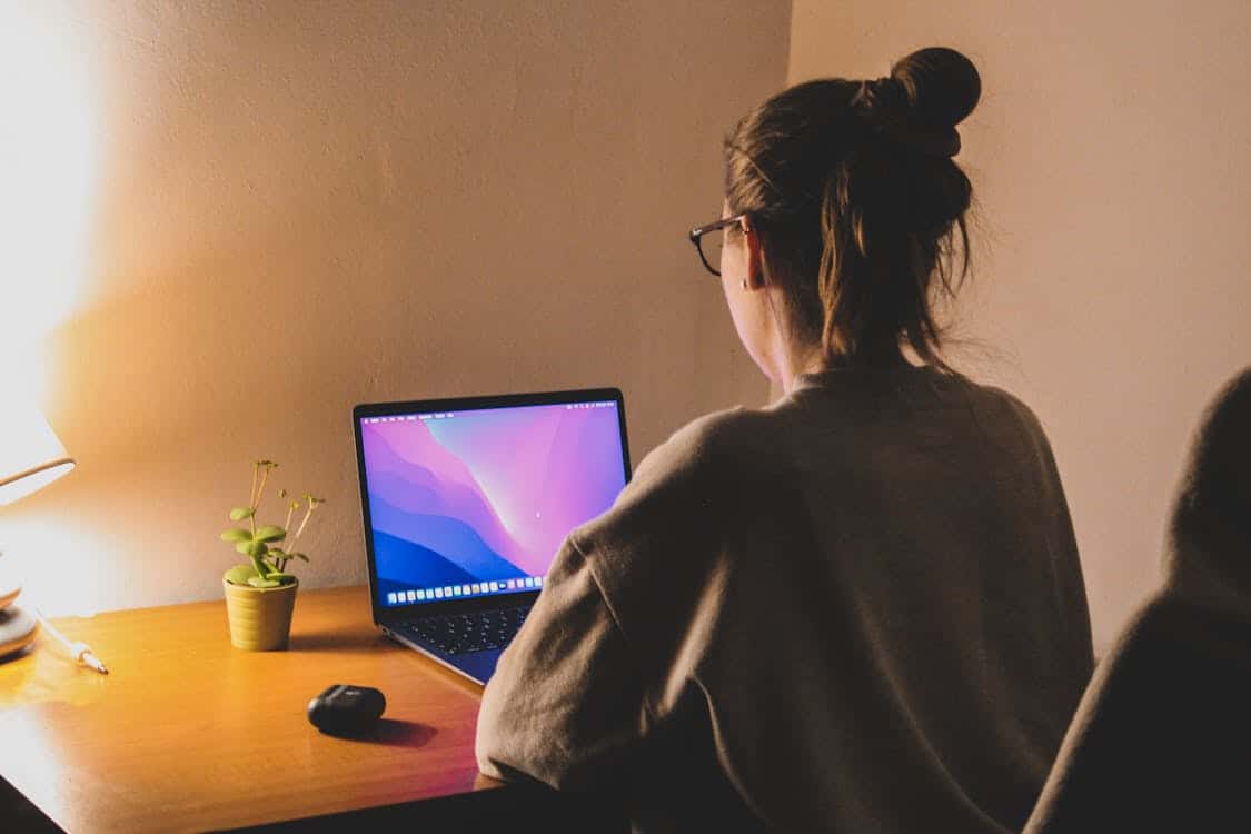 The Time Zone Difference Crushing Remote Workers Is Forcing a Shift to Async Work woman focuses on her laptop at a cozy home office - The Time Zone Difference Crushing Remote Workers Is Forcing a Shift to Async Work