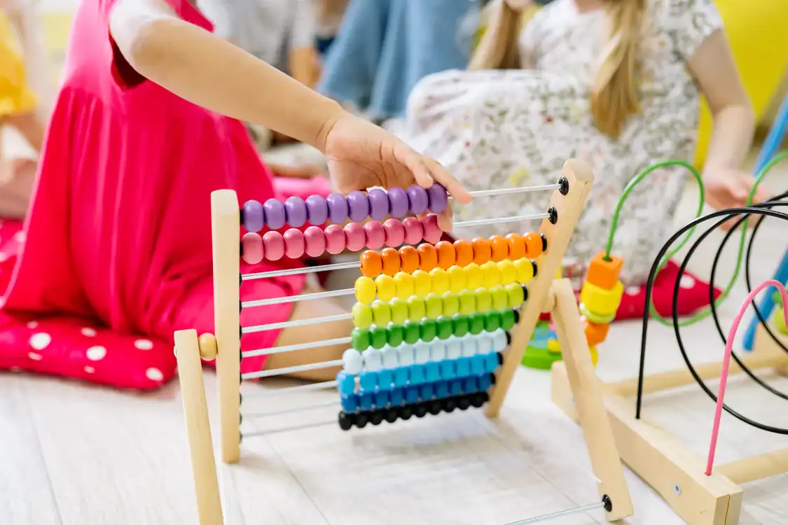 Children actively learning with a colorful abacus - What a National Map of Childcare Deserts Says About Finding a Place on the Gold Coast