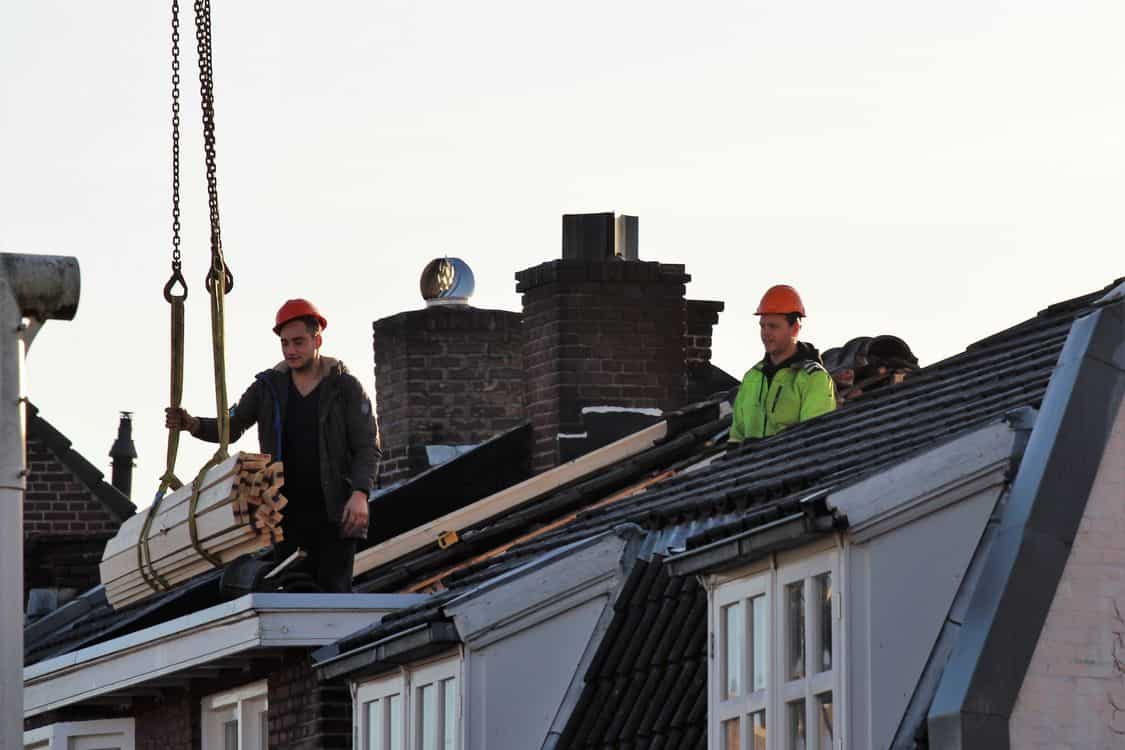 construction workers repairing a roof - The Plywood Tariff Quietly Raising Deck-Repair Bills on Toronto Roof Jobs